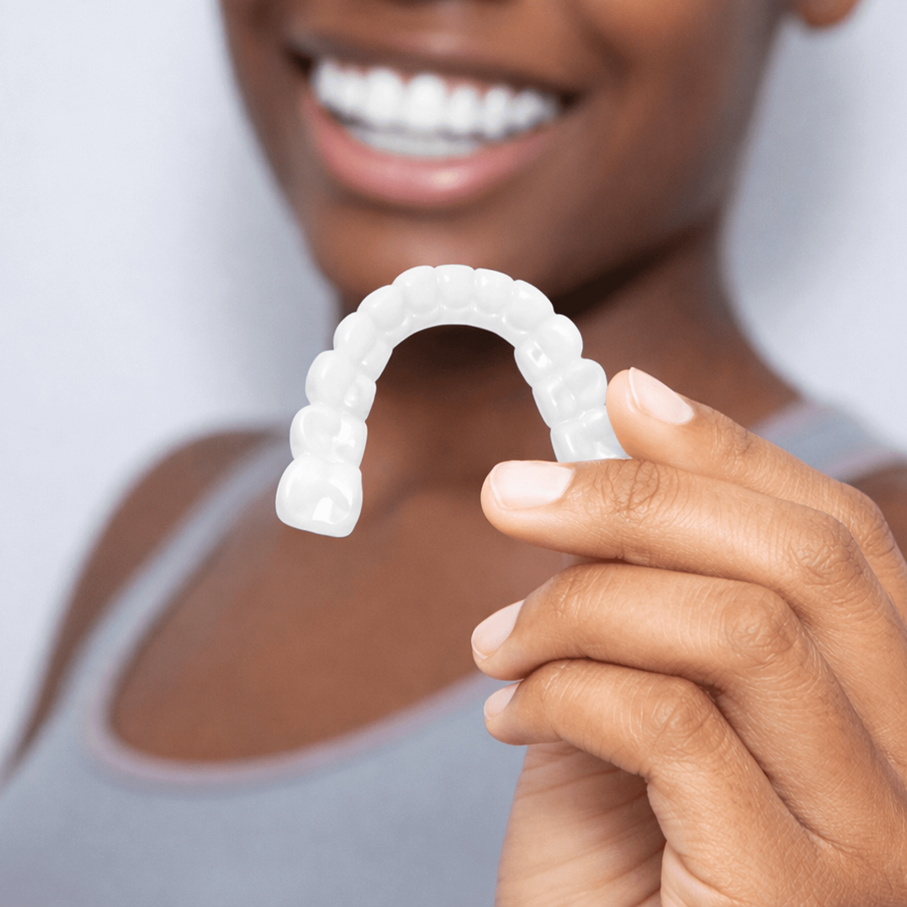 Person holding Pop On Veneers with a blurred background